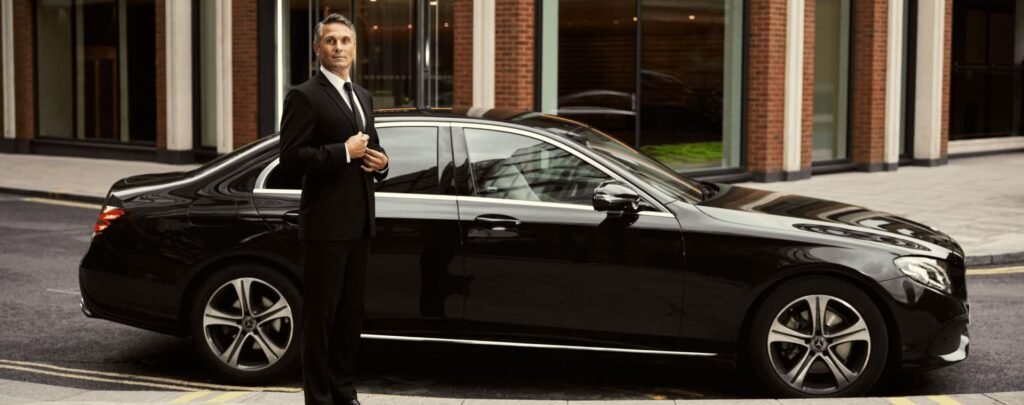 a man in a suit standing next to a car